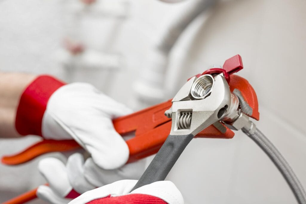 Plumber holding pipe wrenches for an emergency repair in Apopka