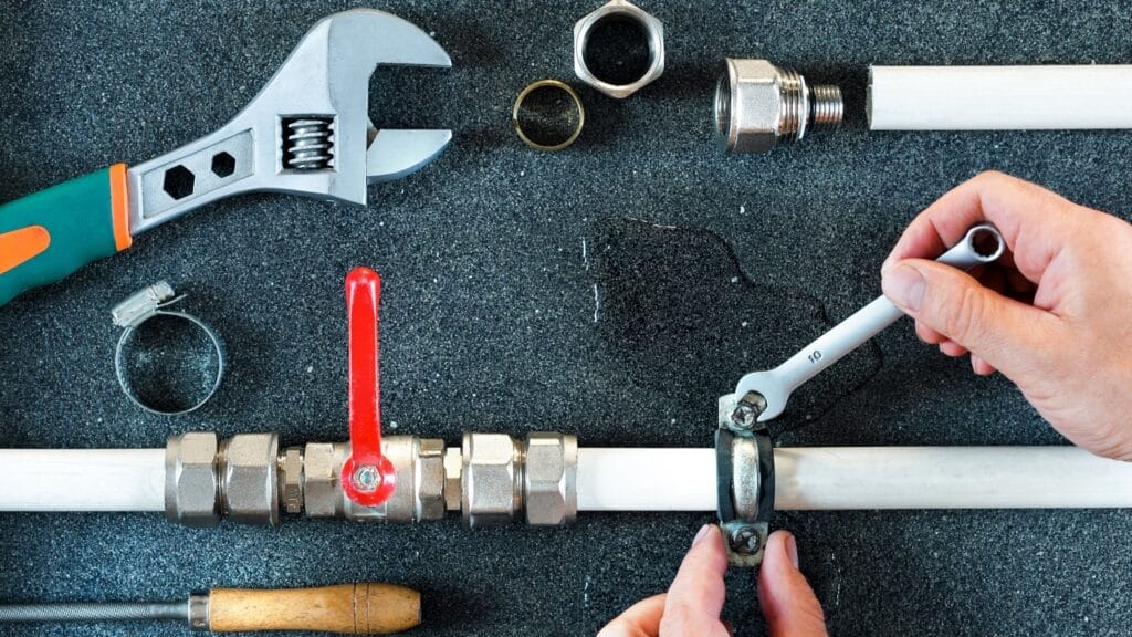 Plumber repairing a pipe valve with an adjustable wrench in Apopka