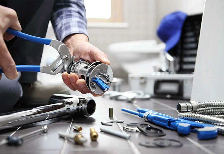 Technician repairing a plumbing fixture with professional tools in Apopka