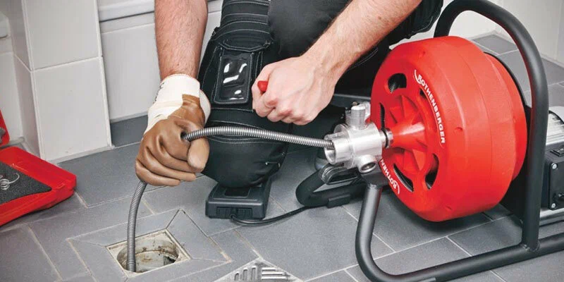 Plumber using a drain-cleaning machine in Apopka
