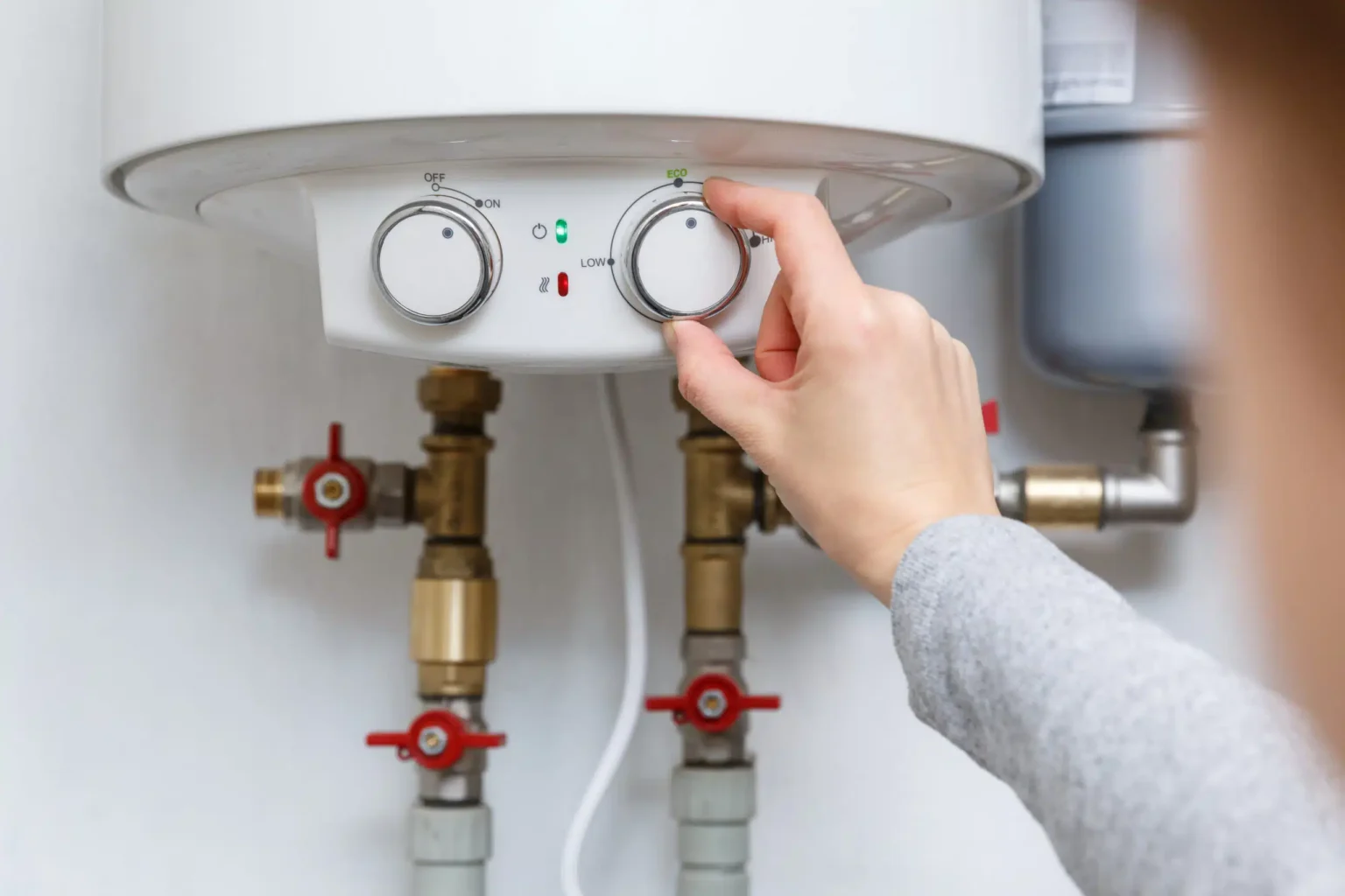 Homeowner adjusting the temperature controls on a water heater in Apopka